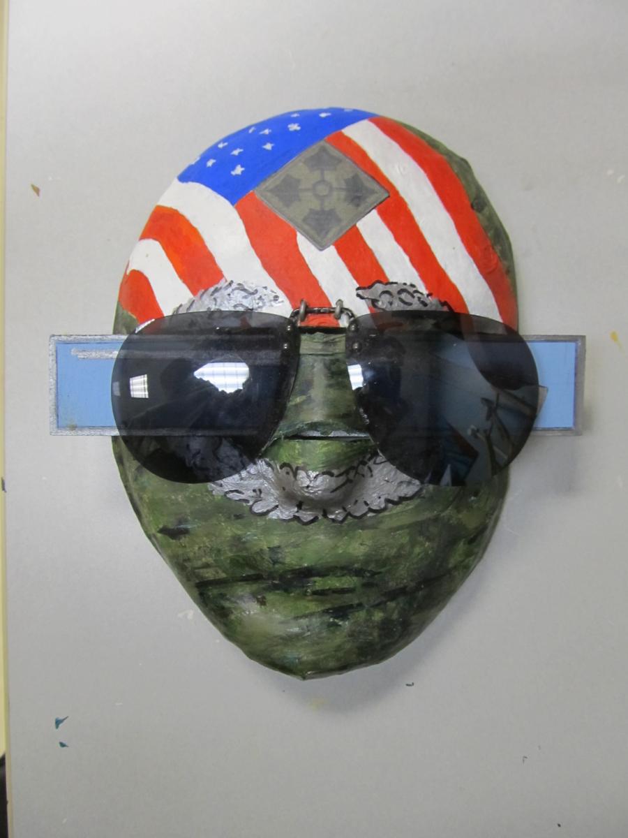 Face with top of head painted as a flag, with sunglasses.