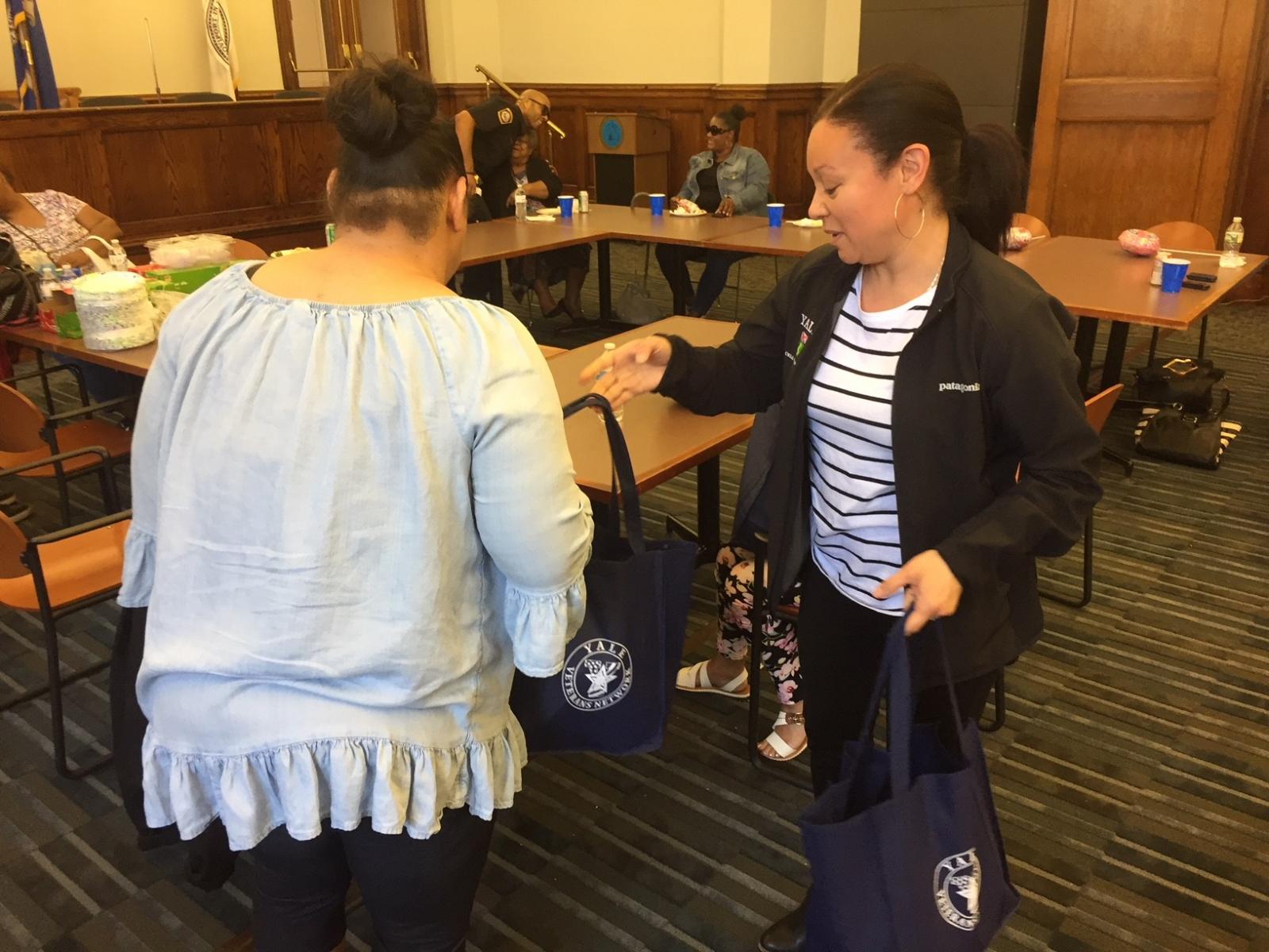 Two women talking by tables.