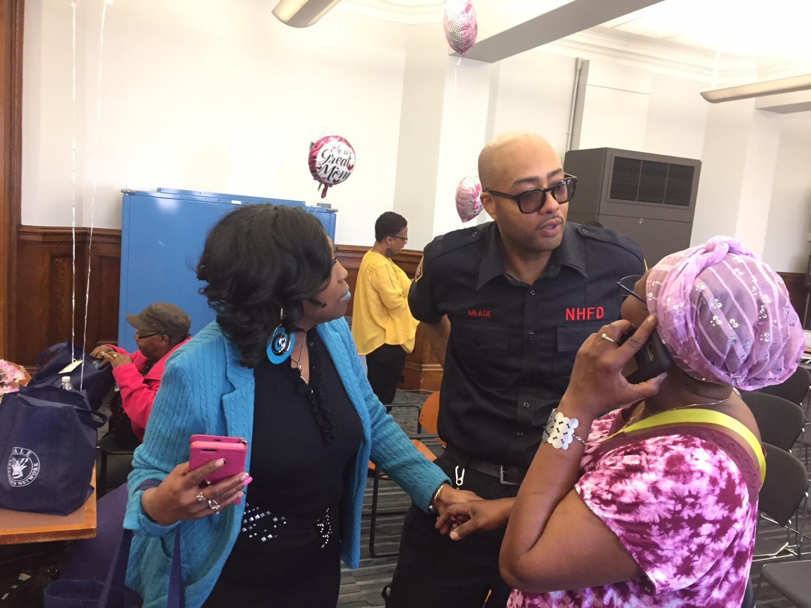 Two ladies talking to a New Haven Fire Department person.