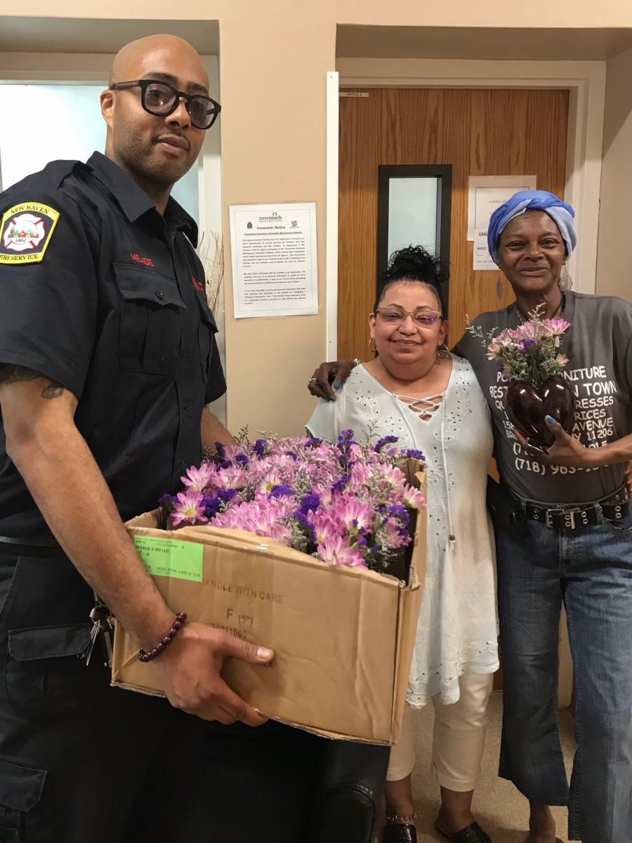 New Haven Fire Department gentleman with two recipients of flowers and a gift bag. 