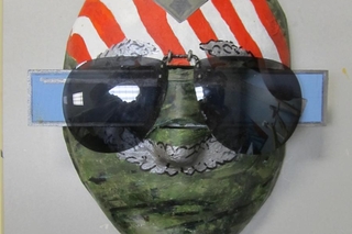 Face with top of head painted as a flag, with sunglasses.