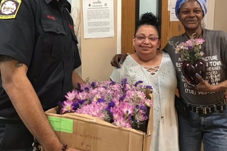 New Haven Fire Department gentleman with two recipients of flowers and a gift bag. 