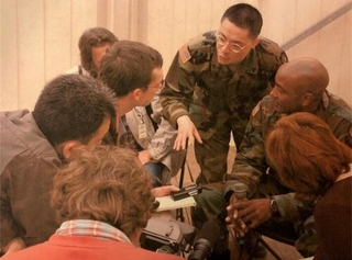 Henry Kwan in uniform interacting with reporters and journalists .while abroad on deployment